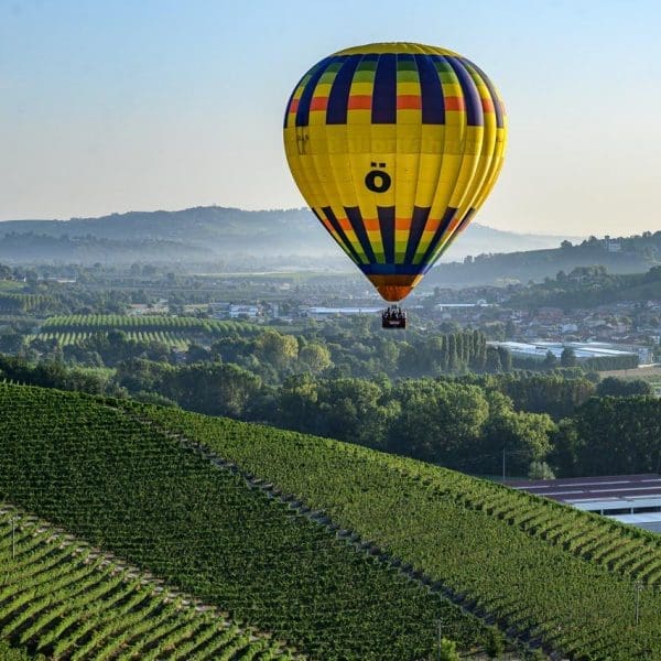Una mongolfiera gialla vola sui vigneti delle Langhe