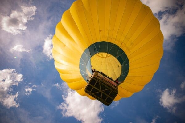 Mongolfiera gialla in volo vista dal basso